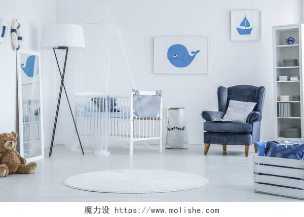 配备木制婴儿床和蓝色扶手椅婴儿房